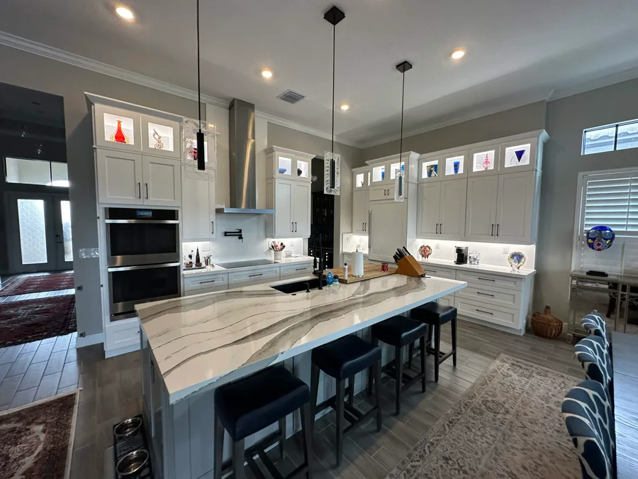 LBS kitchen project with pale cabinetry, a boldly veined island, and pendant lighting