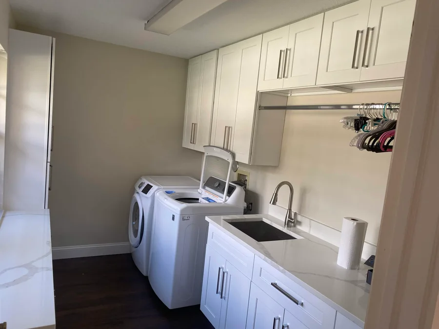 Laundry room with white cabinets, a sink, and countertops