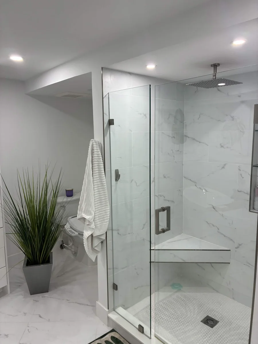 Glass-enclosed shower with a built-in niche and veined wall surfaces